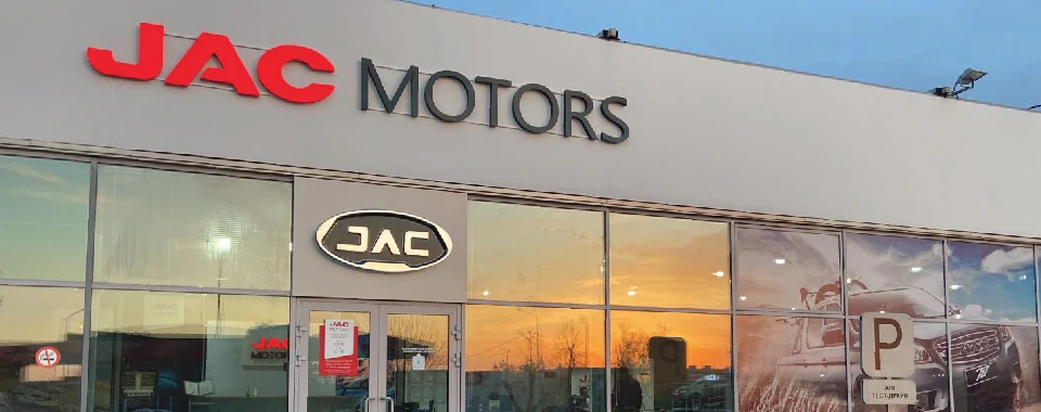 JAC Motors — Фасадная вывеска · вечер